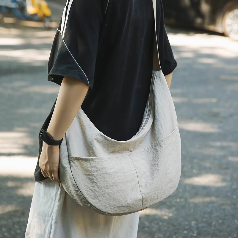 男士斜挎包休闲日系通勤单肩包女生轻便简约饺子包大容量学生背包