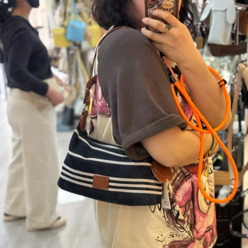 牛皮配水洗布腋下斜挎女包