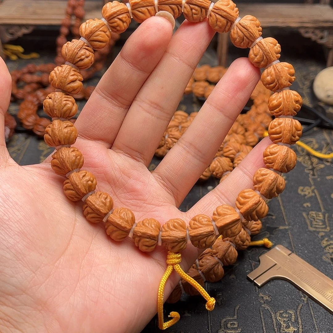 吊坠桃核下小金豆手持