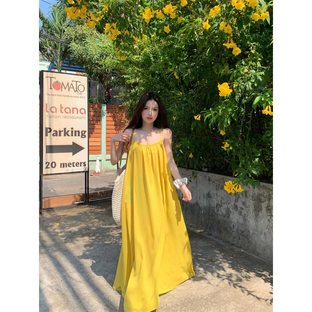 海边度假性感露背吊带连衣裙女夏季新款宽松a字裙温柔黄色长裙子