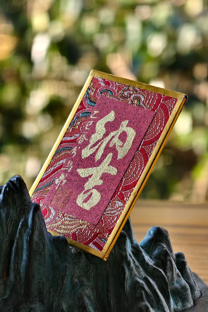 《春分纳吉》乌昂先生金墨亲笔书写，高8.5cm宽6cm。案头摆放春日纳吉