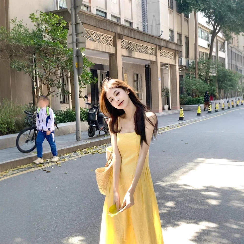 茶歇法式黄色吊带连衣裙女夏季温柔风海边度假收腰显瘦沙滩长裙子