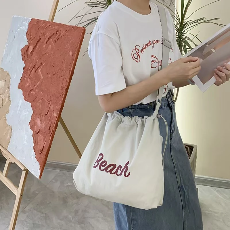 韩版简约字母大容量通勤外出包抽绳束口袋斜跨单肩可调节