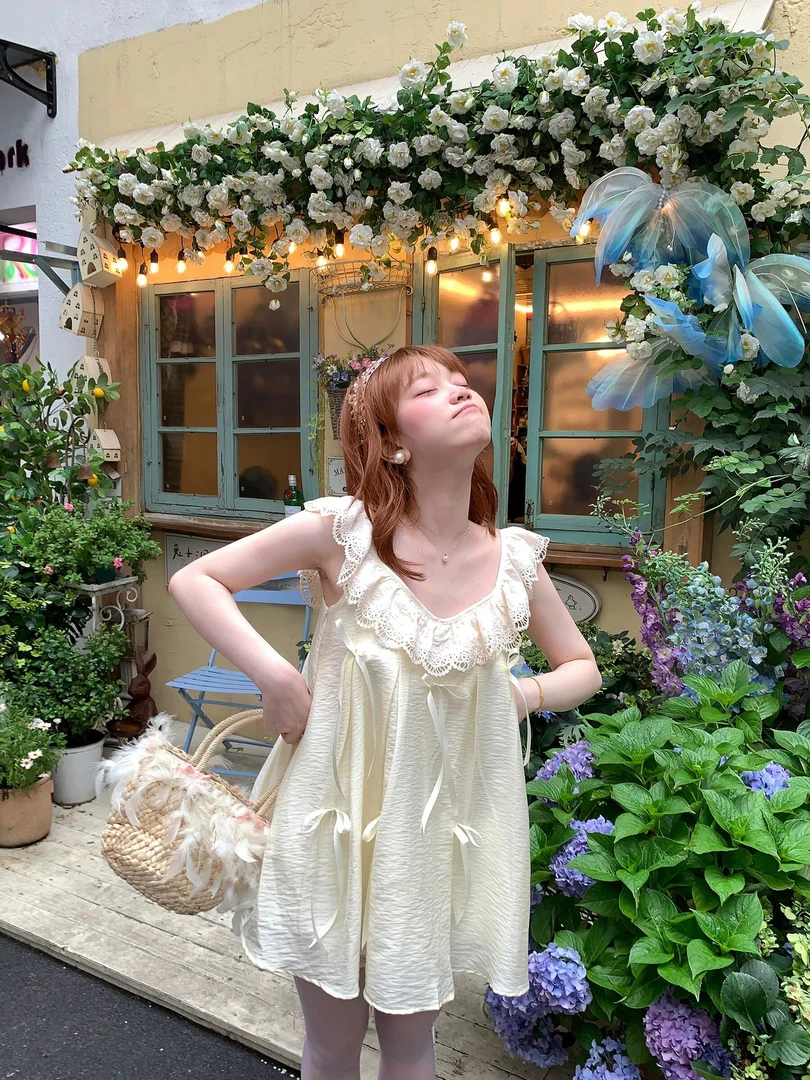 法式纯欲杏色时尚褶皱蝴蝶结吊带连衣裙女蕾丝拼接宽松显瘦短裙