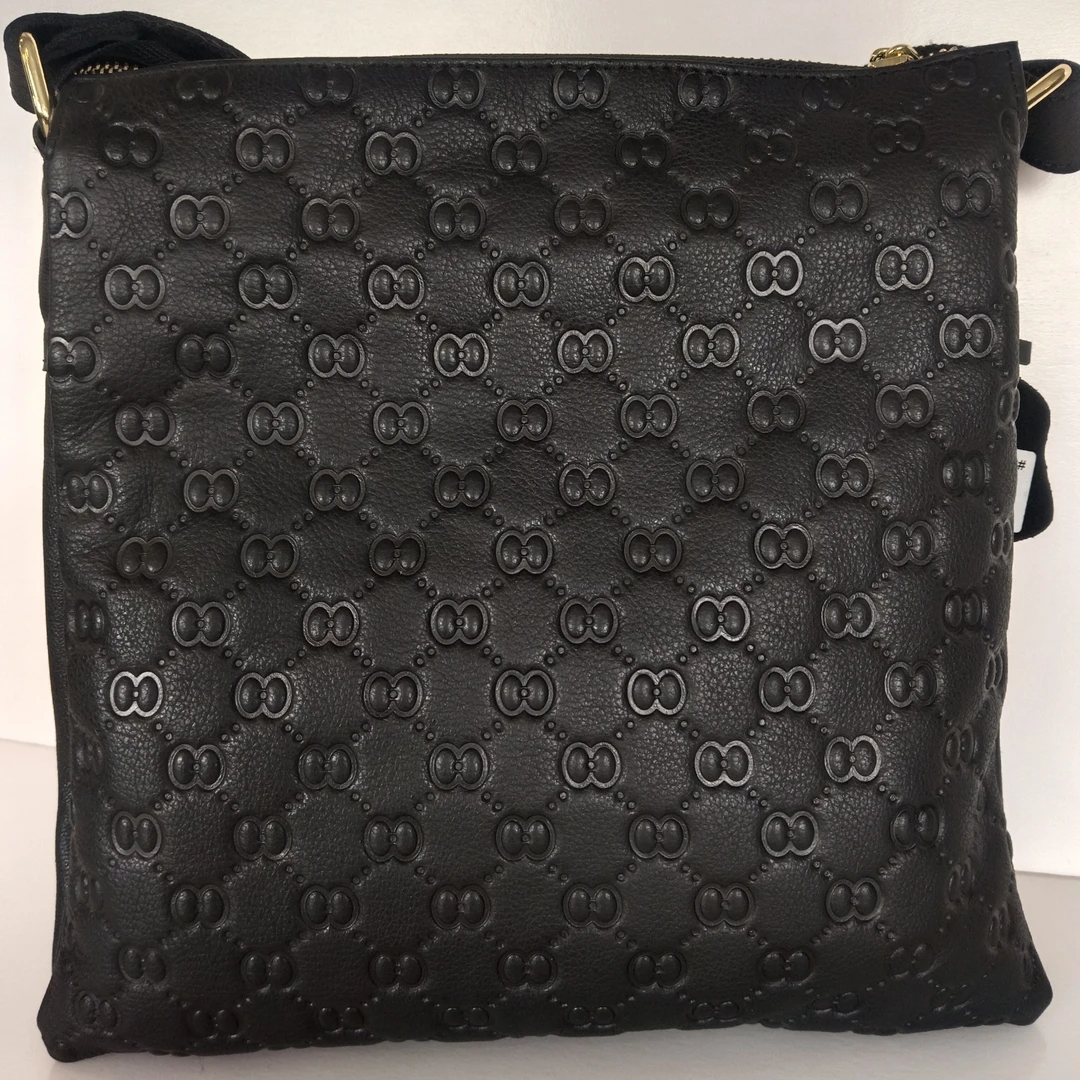 经典黑色斜挎包，标志性压纹图案彰显独特品味。大容量设计