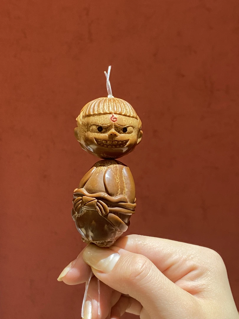 哪吒手盘橄榄核雕件