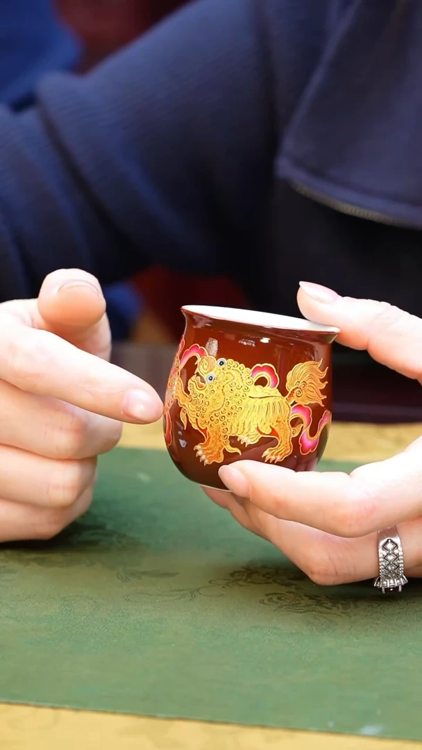 紫金釉狮迎百福布袋杯