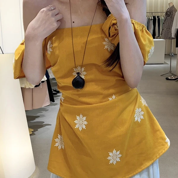 十三行2025夏季法式复古度假风一字肩上衣褶皱收腰黄色上衣女